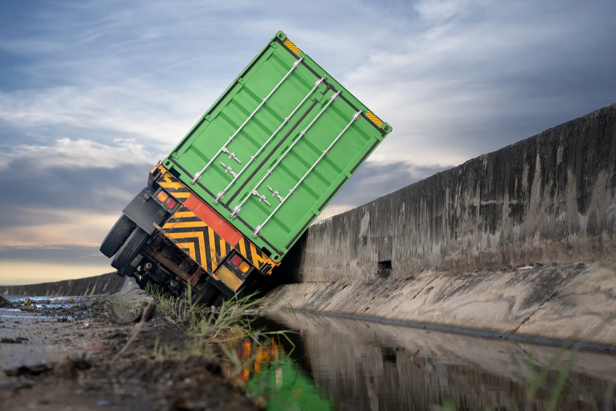Truck tipped over into a ditch beside a road.