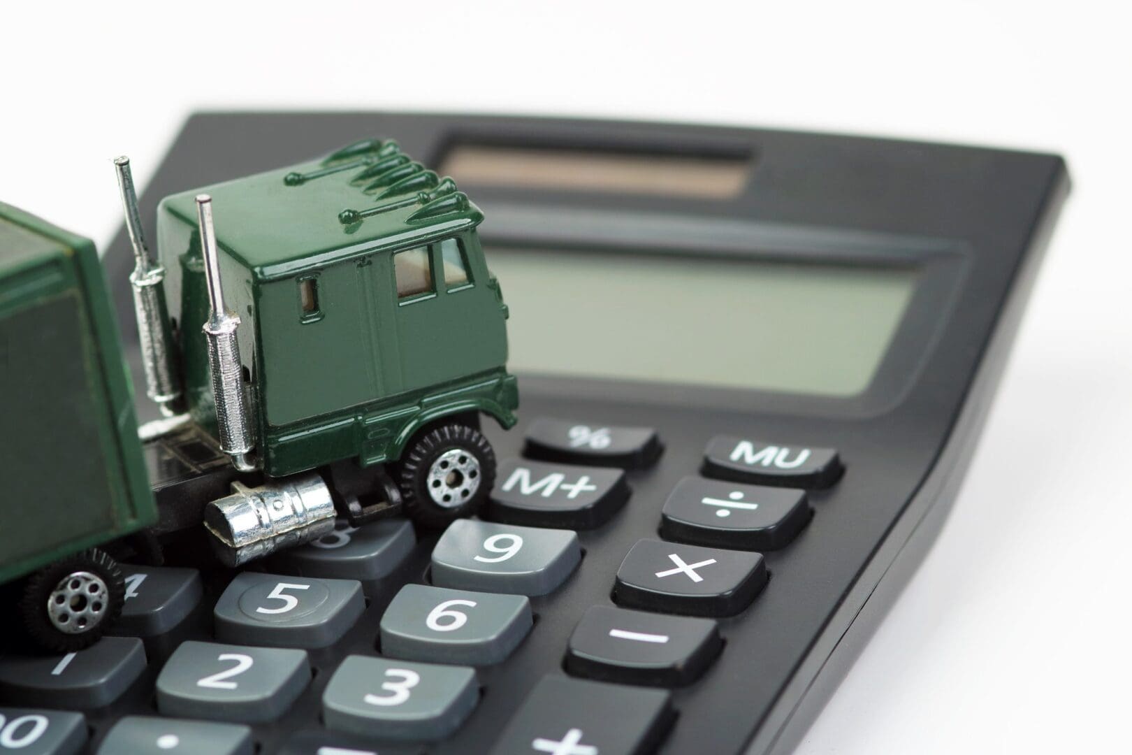 Toy truck sitting on a calculator keyboard.