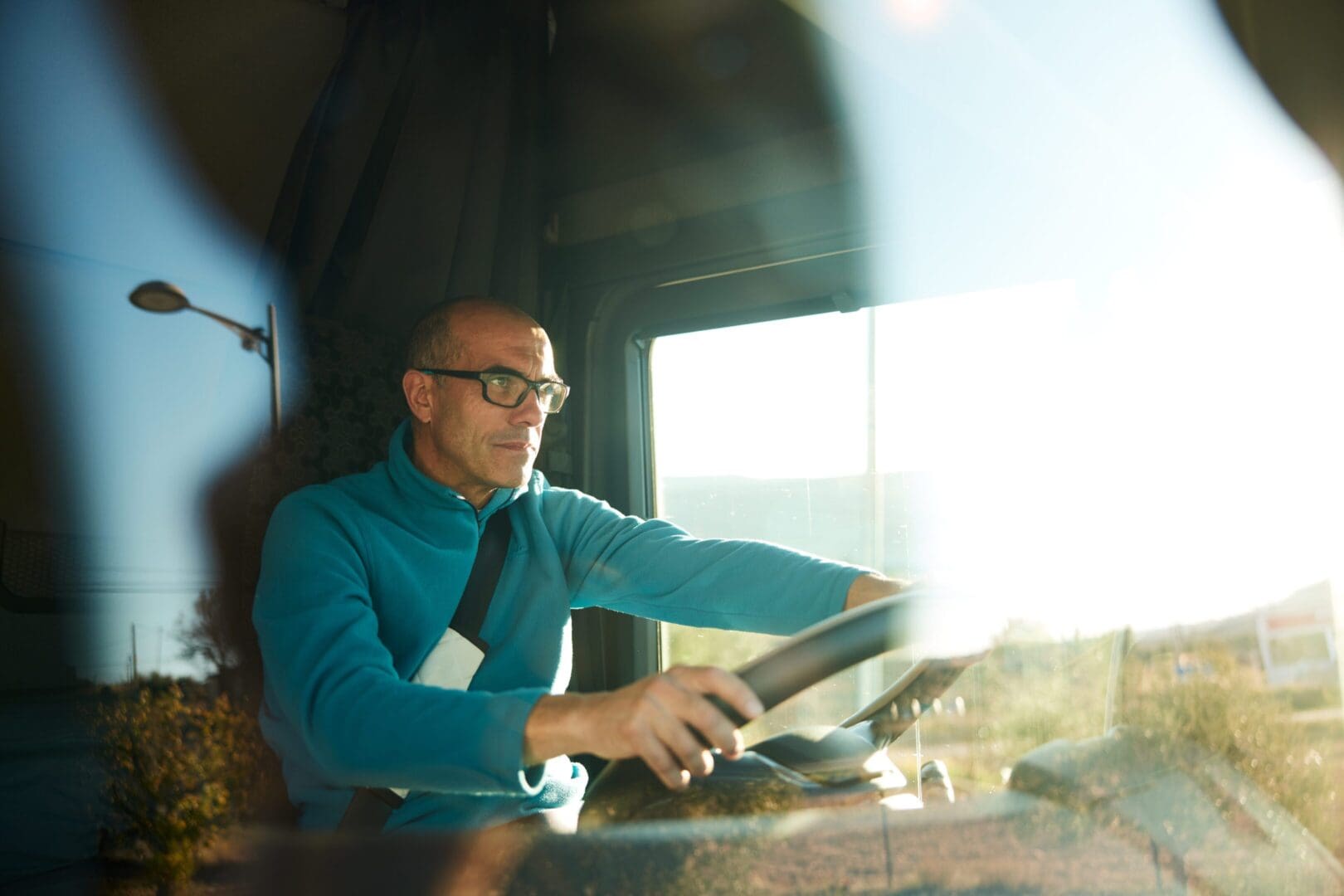 A man driving a vehicle, looking focused.